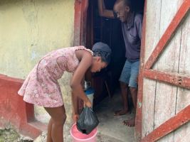 Ritchie giving some food to Er, an elderly man with no one to help him.