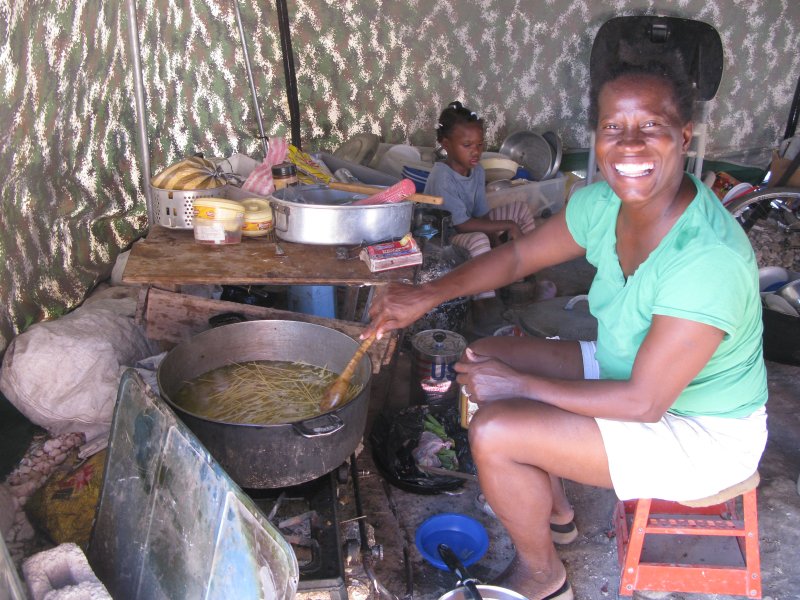 Yvrose cooking for her family in their tent