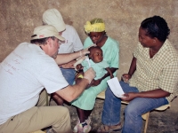 Dr. Hamilton with Yvrose translating treats a patient in the mountains