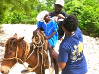 Yvrose giving ORS to a child with cholera coming down on the trail.