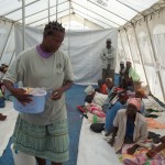 Yvrose passing out hygiene items to cholera patients