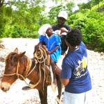 Yvrose giving a sick child ORS on the trail