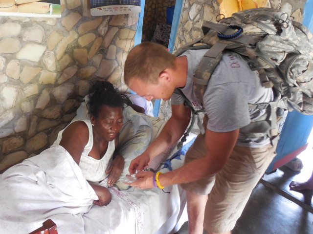 Cody giving medicine to a woman at her home.