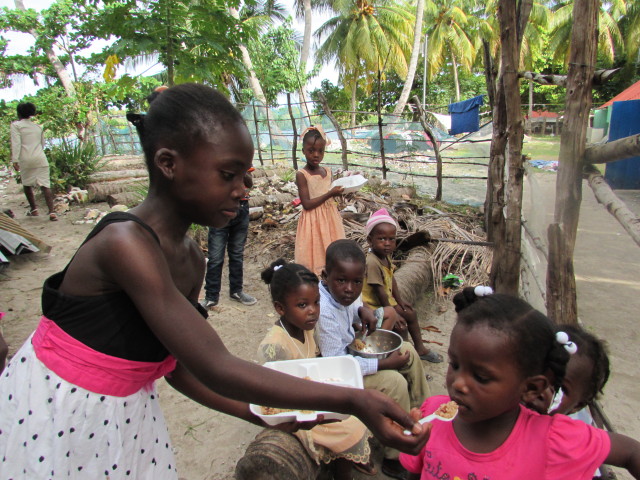 One of our neighborhood children sharing her food with another.