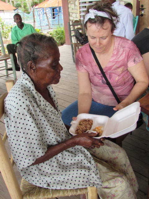 Kim helping an elderly neighbor with her meal