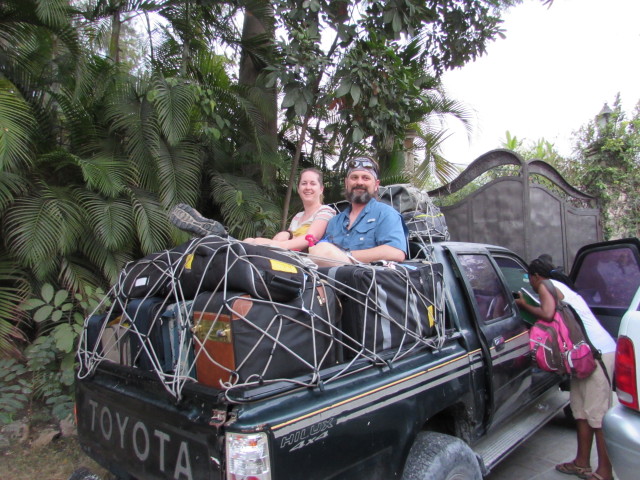Aaron & Emily riding on the luggage in the truck 